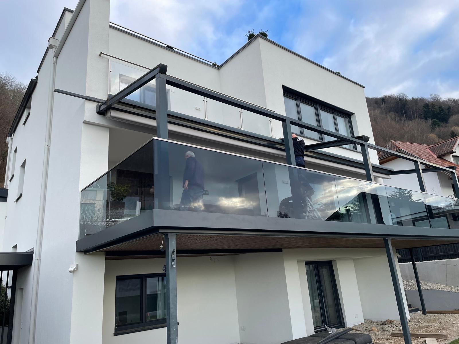 Balkon mit Glasgeländer und Stahlüberdachung
